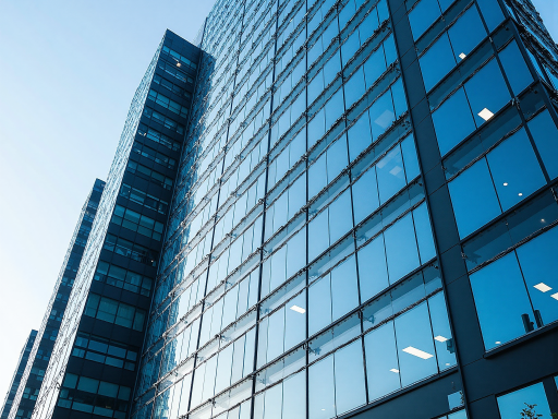 Modern office building exterior with glass facade and corporate signage, blue sky background
